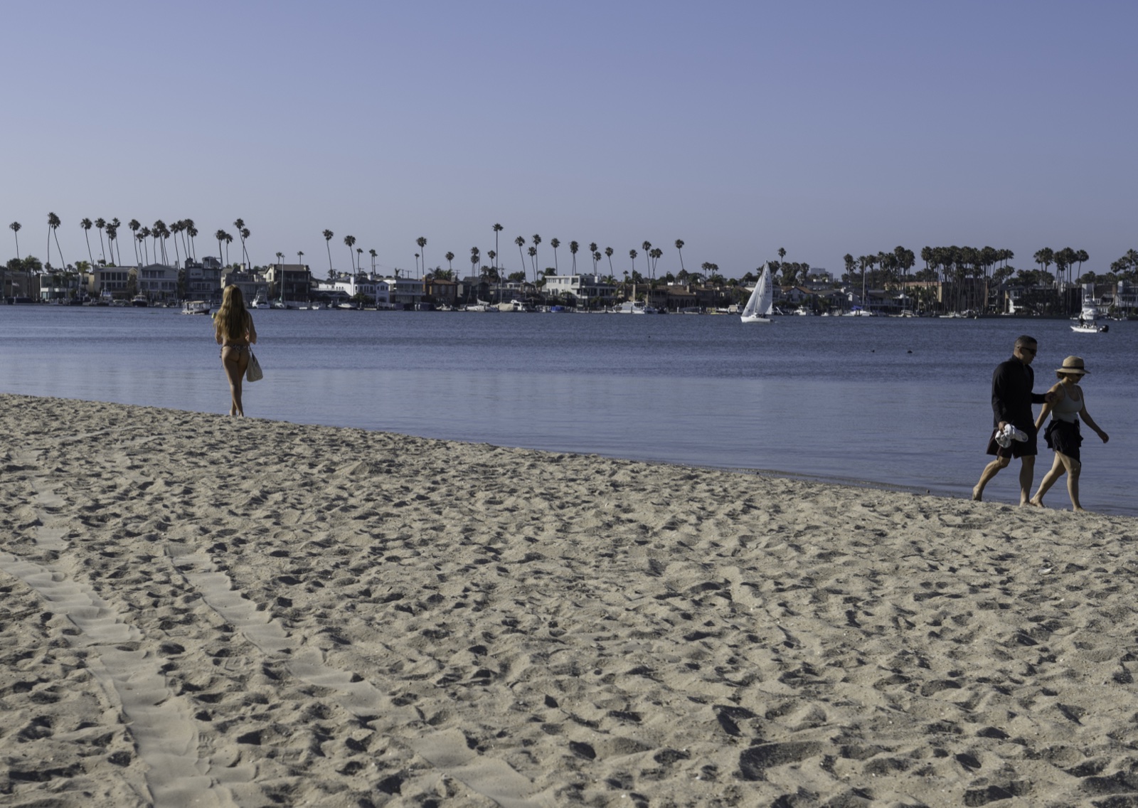 Alamitos Bay beach — family walking with sailboat in background
